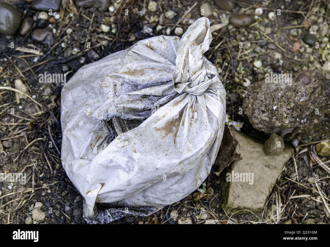 Plastic garbage bag on the ground, climate change and pollution Stock
