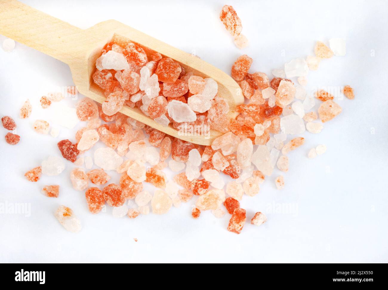 coarse Himalayan pink rock salt with wooden scoop and copy space Stock