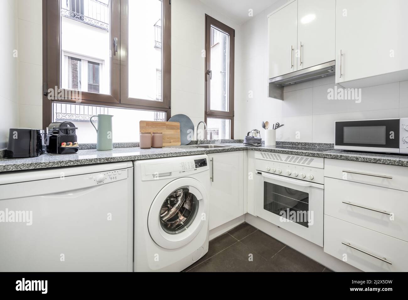 White kitchen with matching appliances, gray granite countertops and