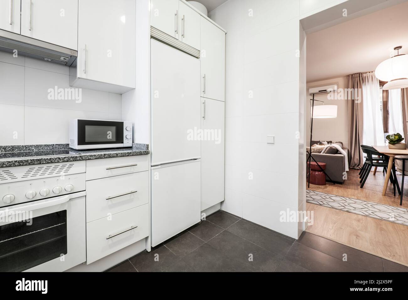 White kitchen with matching appliances, gray granite countertop, white