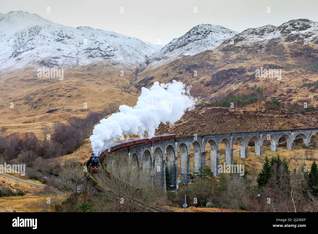 Steam train &quot;Jacobite Express&quot; under smoke, Glenfinnan Viaduct, Highlands, Scotland, UK Stock Photo