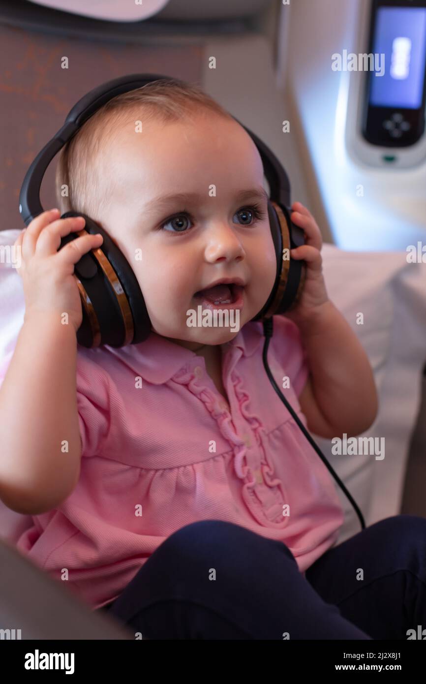 Oneyearold toddler enjoying her first business class flight with many