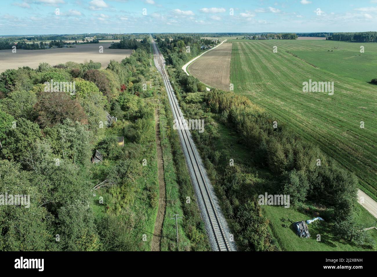 The beautiful countryside landscape with a railroad surrounded by green ...