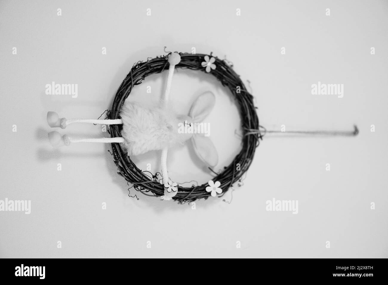A grayscale shot of a dreamcatcher with a cute rabbit toy inside of it Stock Photo