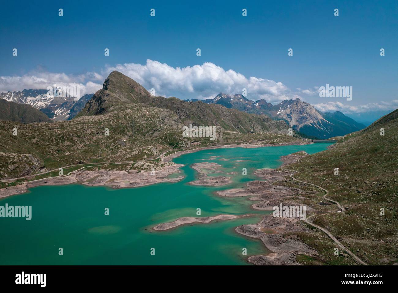 Landscape at the Lago Bianco reservoir at the Bernina Pass in the sun from above Stock Photo