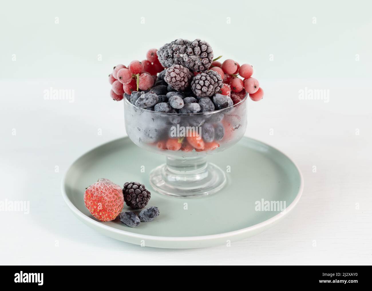 A mix of frozen berries in a transparent bowl. Berries are rich in
