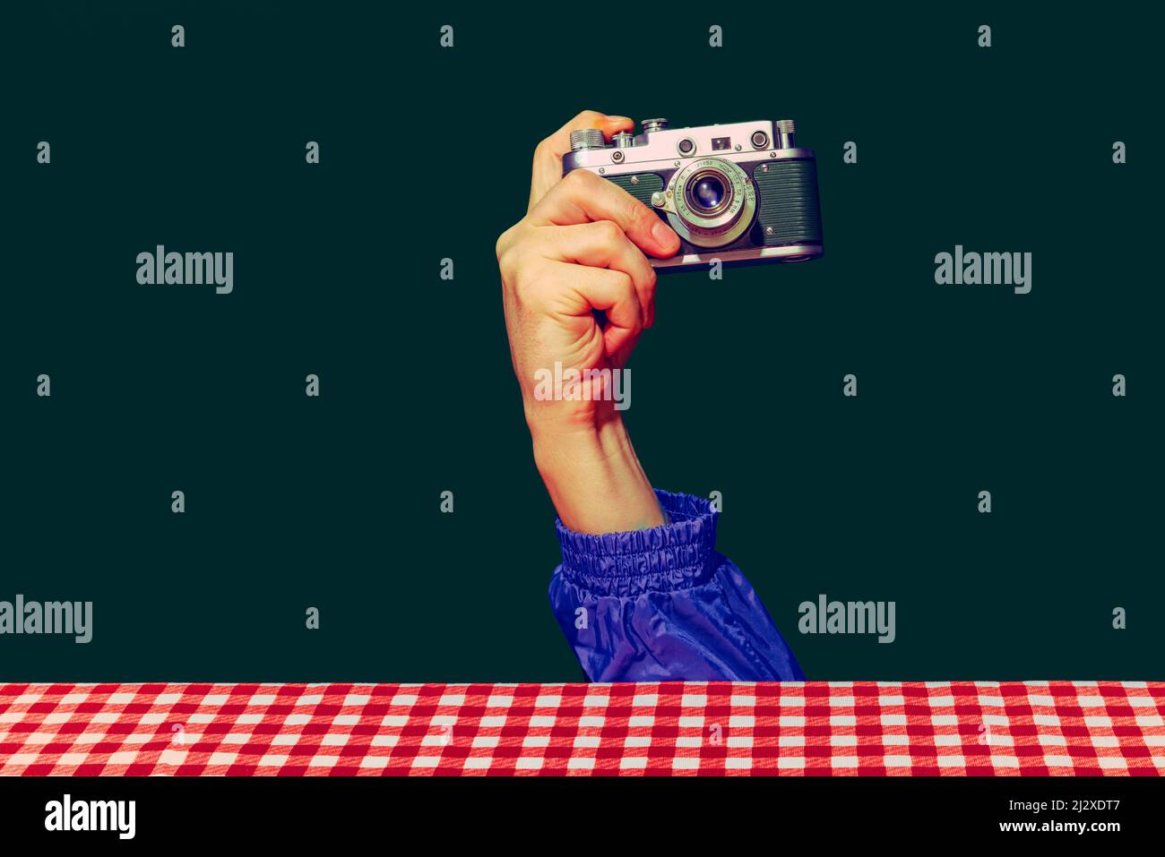 Concept of pop art photography. Using retro gadgets. Human hand holding photo camera isolated on green background. Vintage fashion style. Concept of Stock Photo