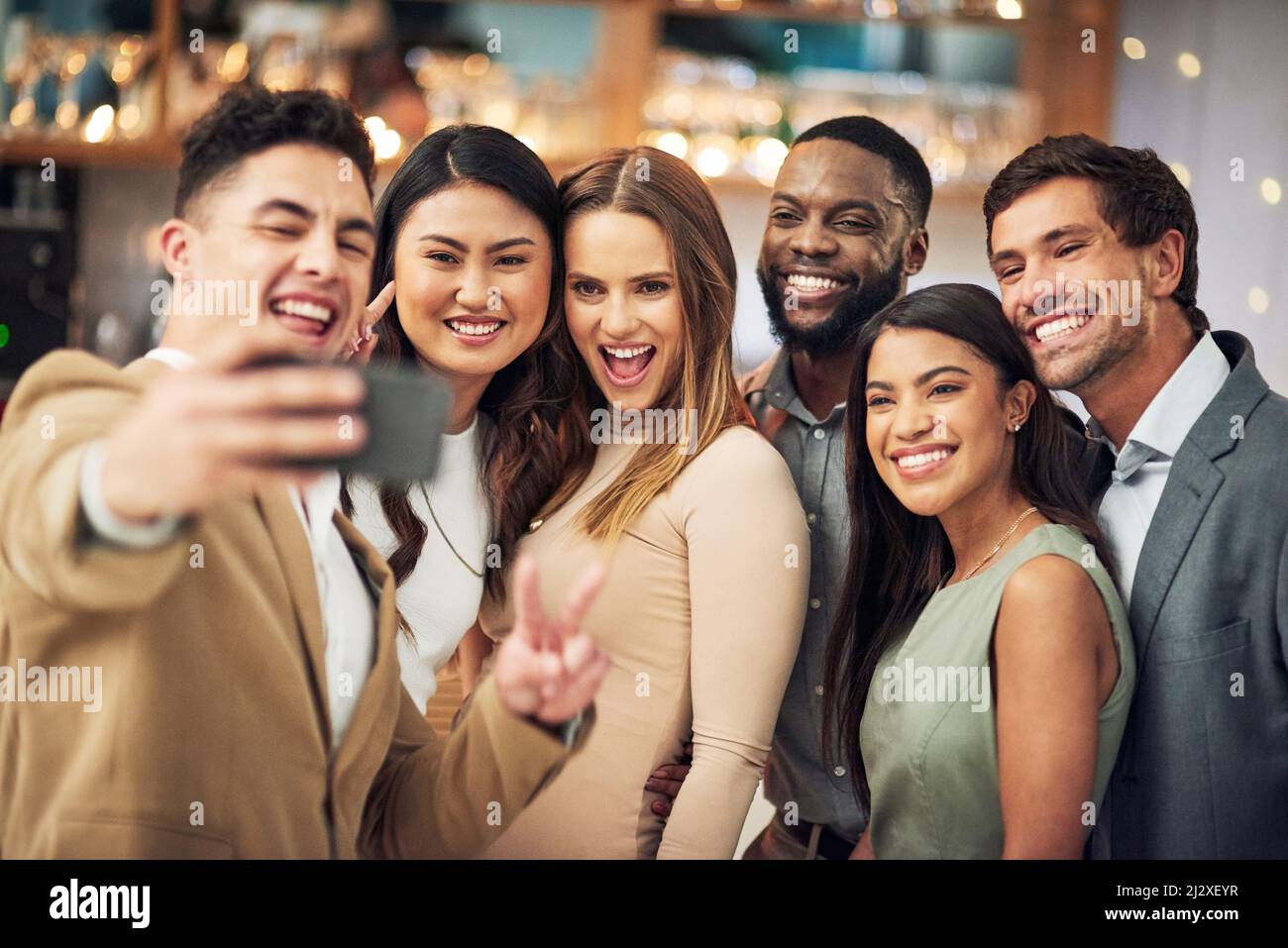 A quick selfie while the fun lasts. Cropped shot of a group of young friends posing for a selfie together in a bar. Stock Photo
