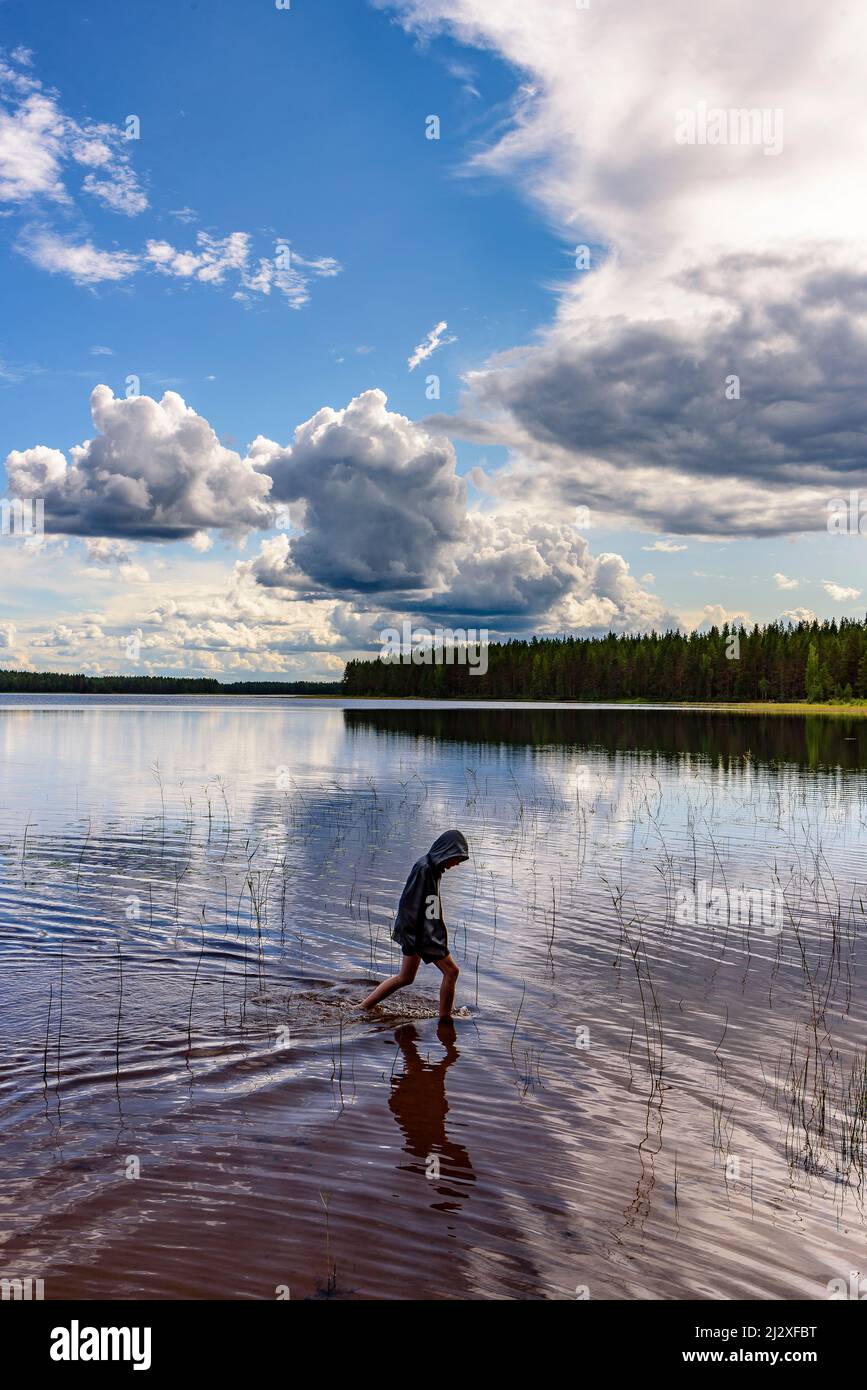 Boy on the shore in Patvinsuo National Park, Finland Stock Photo