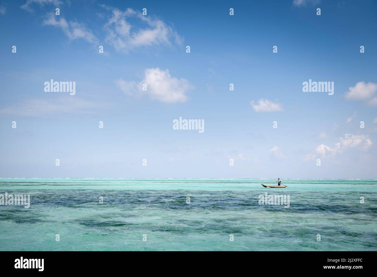 Local people in dugout boat, crystal clear water, Nosy Nato, Ile aux Nattes, Madagascar, Indian Ocean, Africa Stock Photo