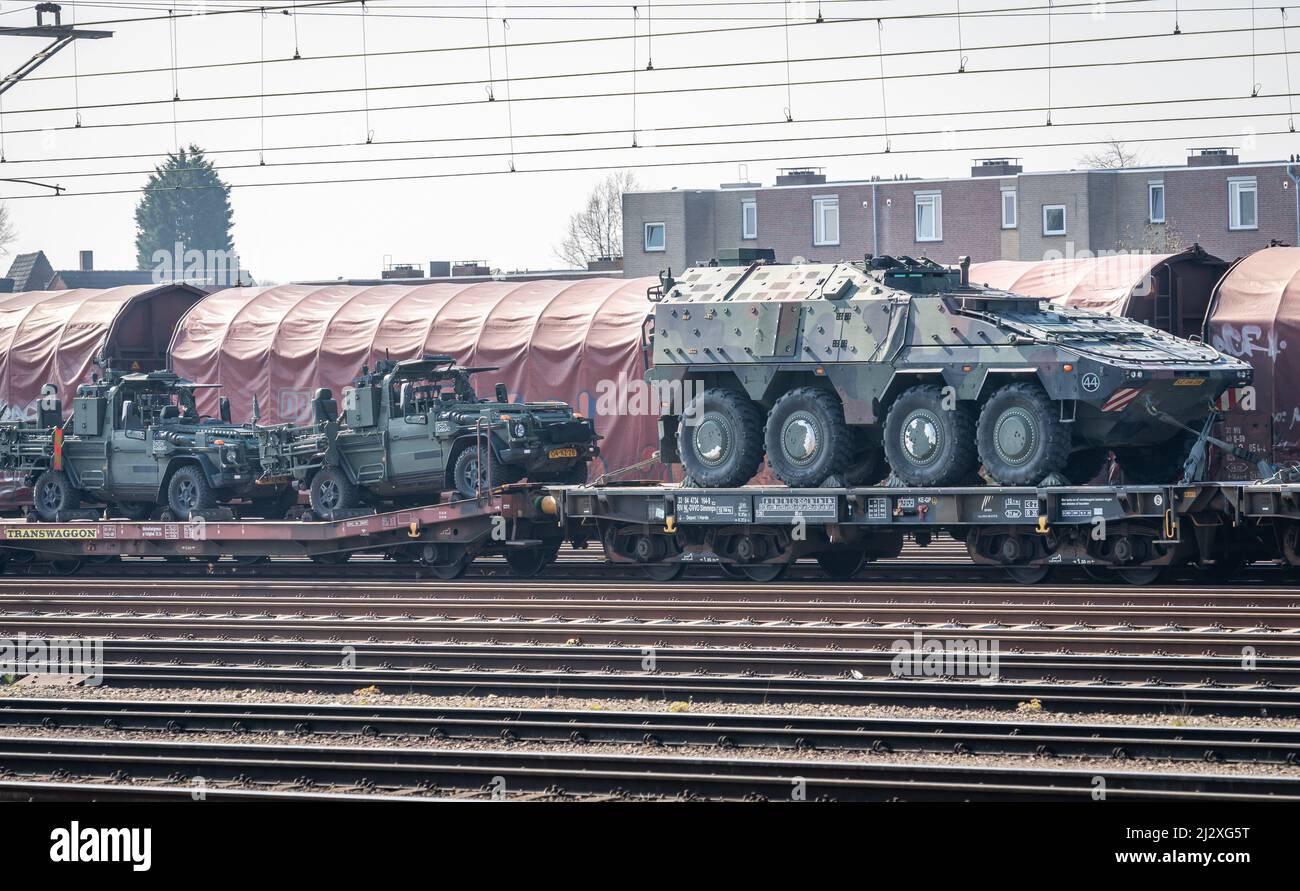 Cargo train transporting armored personnel carriers and military jeeps Stock Photo