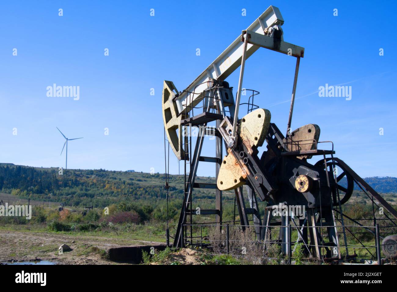 an oil pump is on a background mountains Stock Photo