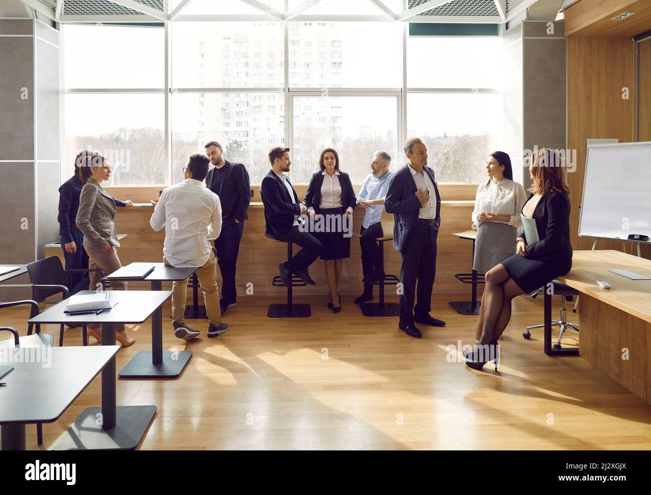 Diverse people gather in groups and talk during break at business team