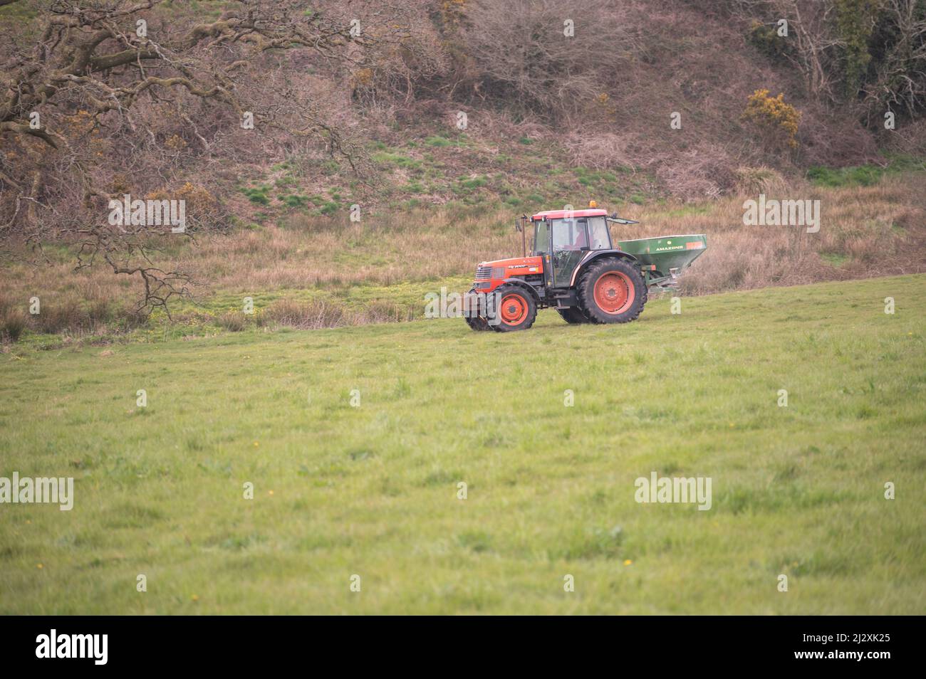 Farmer spreading artificial fertiliser on grass field Stock Photo Alamy