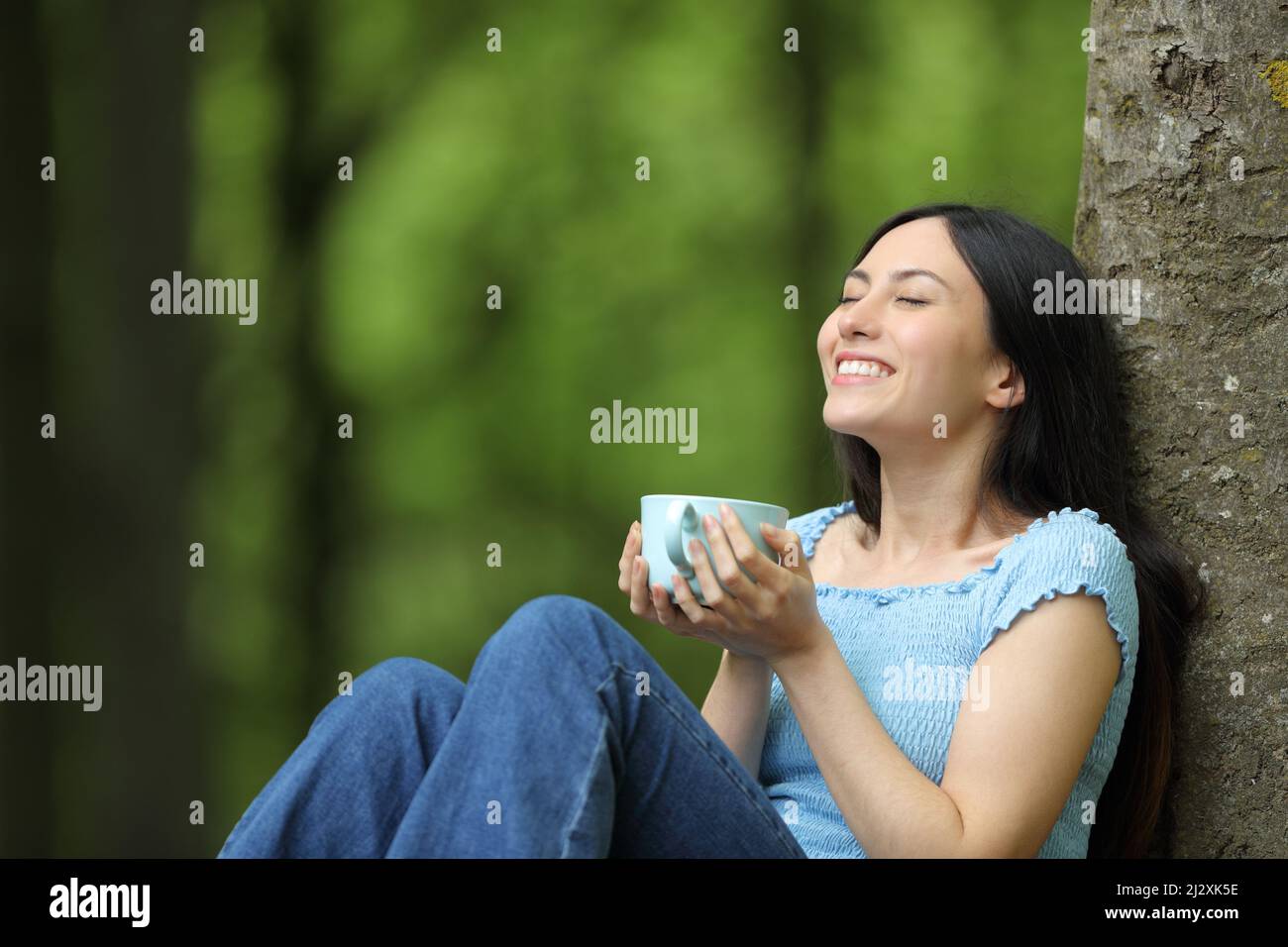 Happy asian woman enjoying coffee relaxing sitting in a park Stock ...