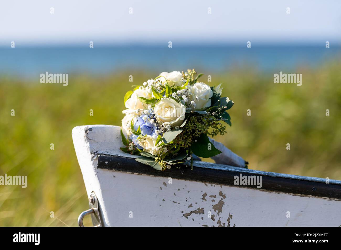 Bouquet of flowers with roses and hydrangeas on the tip of a wooden boat Stock Photo