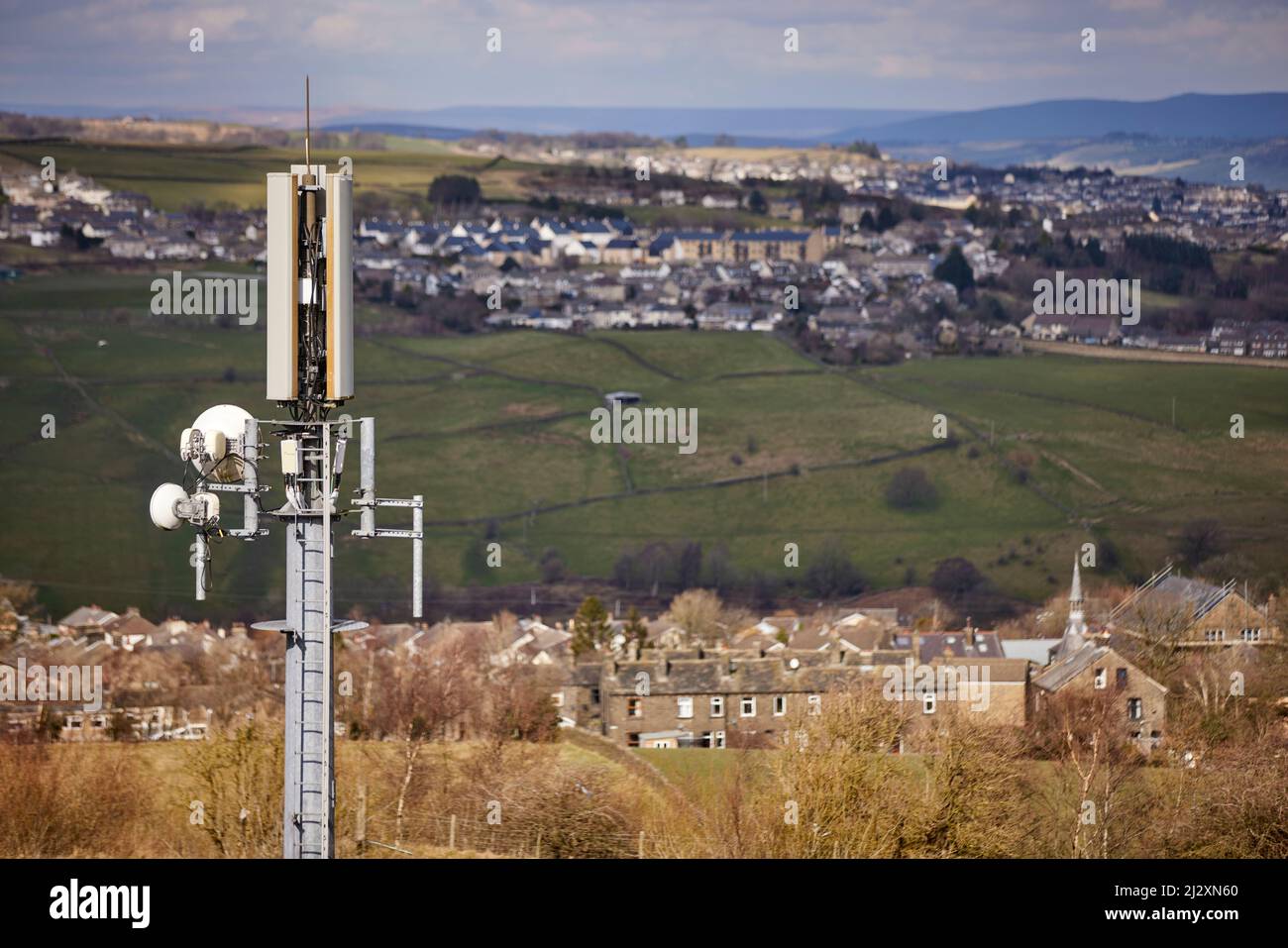 A mobile phone mast antennae  towering over the Yorkshire village of Howarth Stock Photo