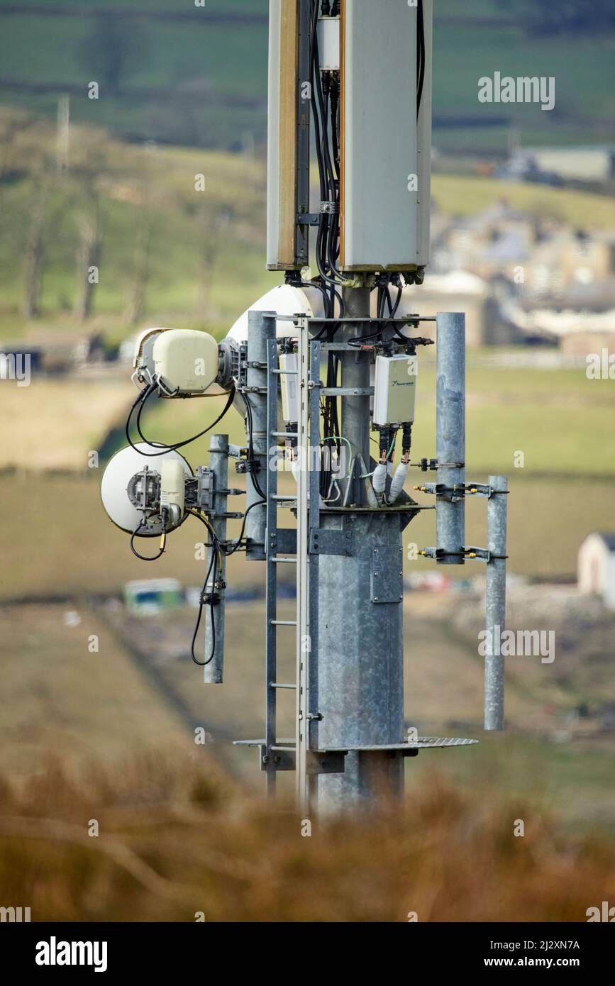 A mobile phone mast antennae  towering over the Yorkshire village of Howarth Stock Photo