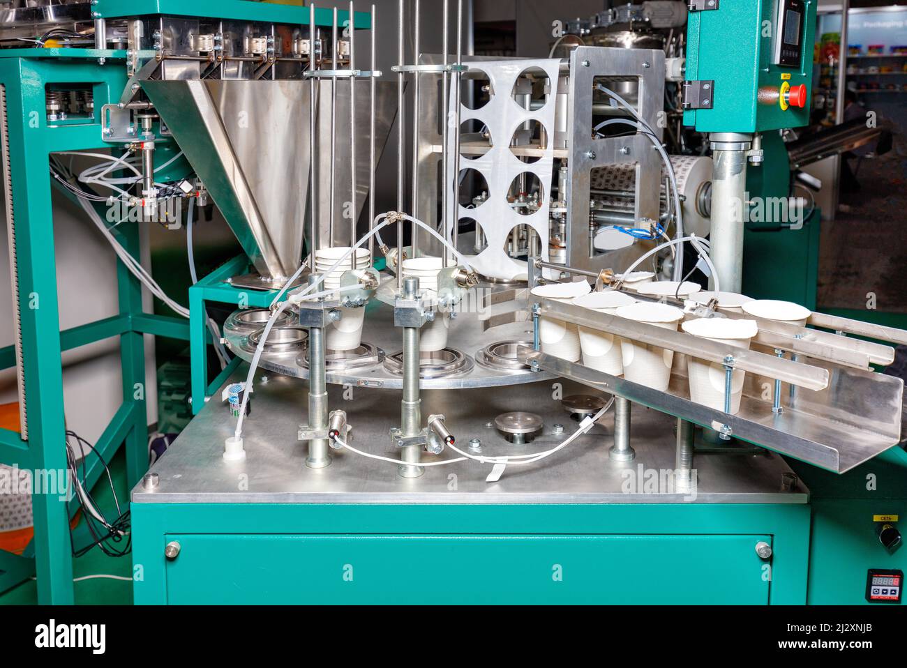Production automatic line for bottling and packaging of yoghurts controlled by software. Stock Photo