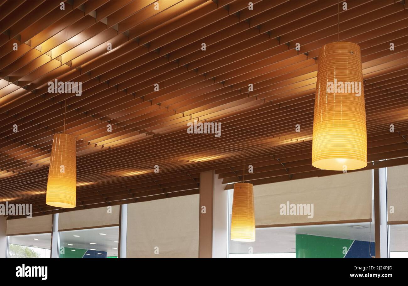 Modern ceiling lighting, details of lamps and wooden constructions. Stock Photo
