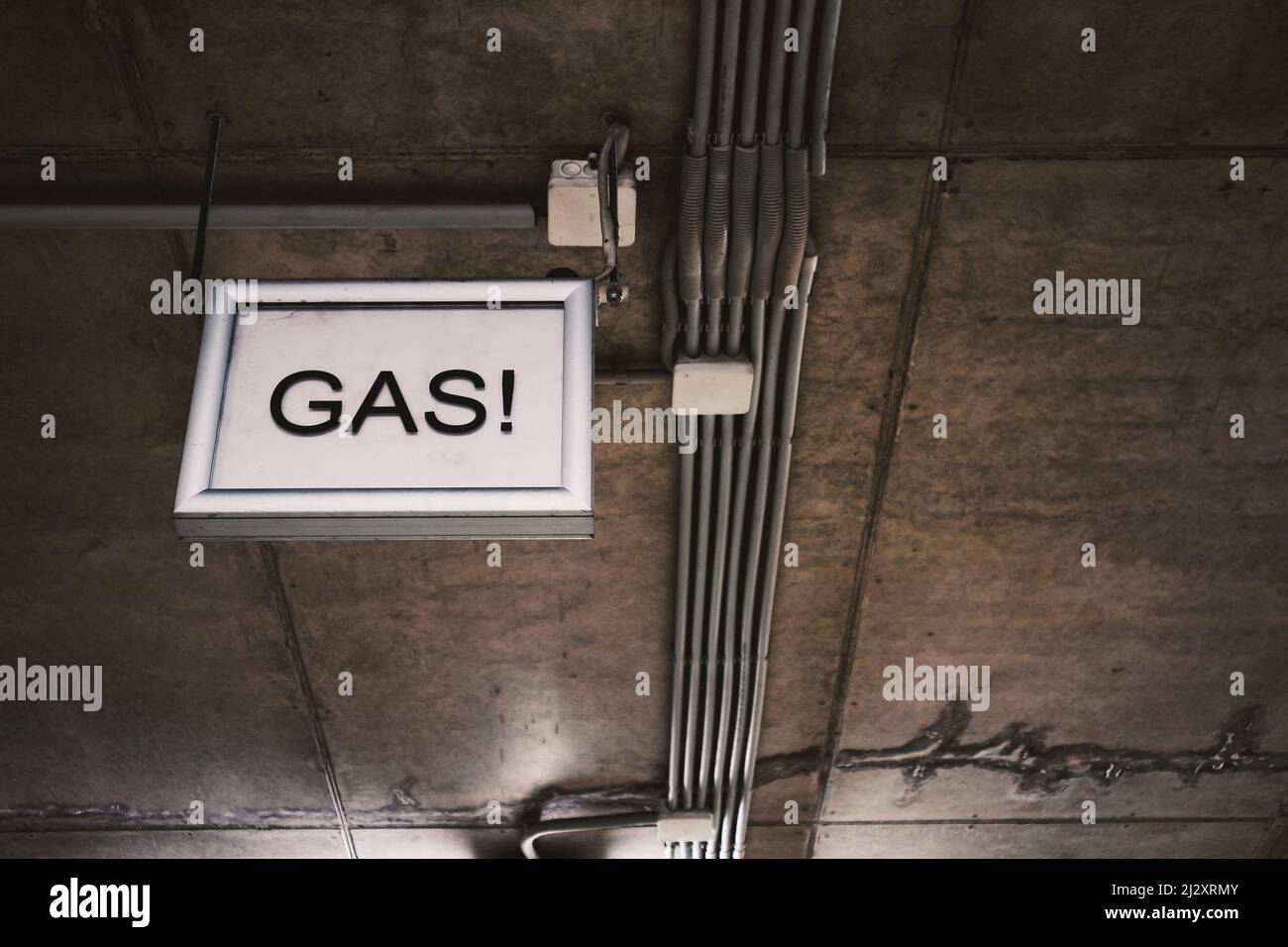 Ceiling infrastructure in the garage with gas sign, details. Stock Photo