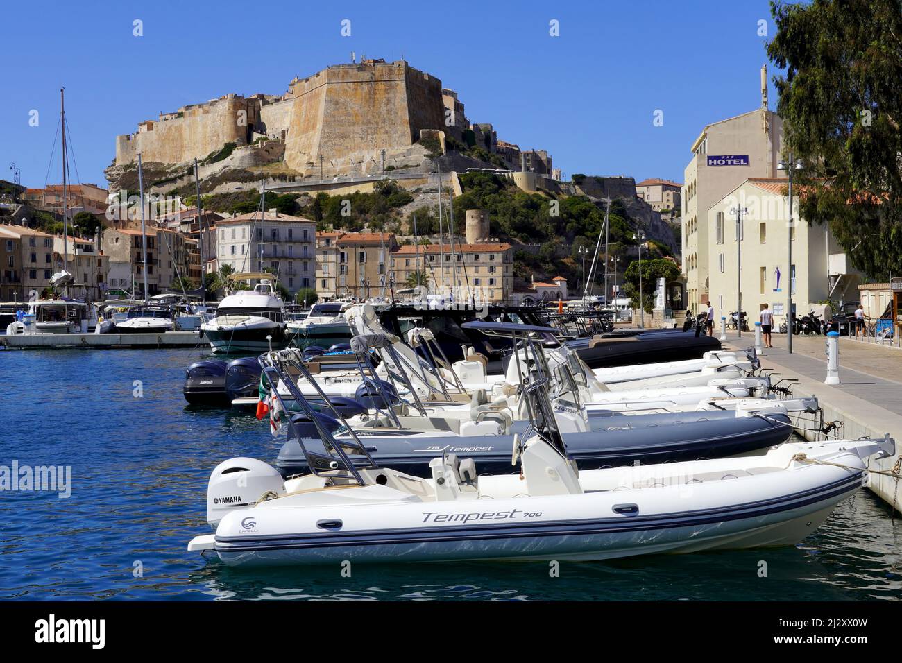 Bonifacio, southern Corsica: boat lying at anchor in the marina, at the bottom of the citadel In the foreground, Yamaha Tempest inflatable boats Stock Photo