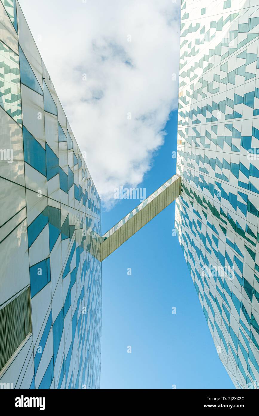 Transition block between two buildings of modern Bella Sky Comwell Hotel against the blue sky with clouds in Ørestad, Copenhagen, Denmark Stock Photo