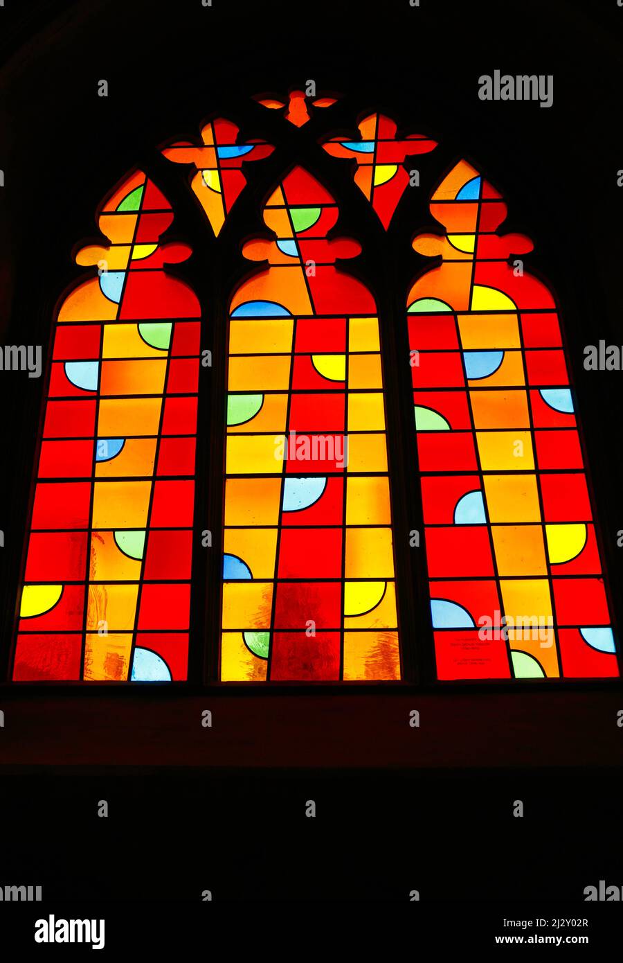 A view of one window of a triptych of modern stained glass by John
