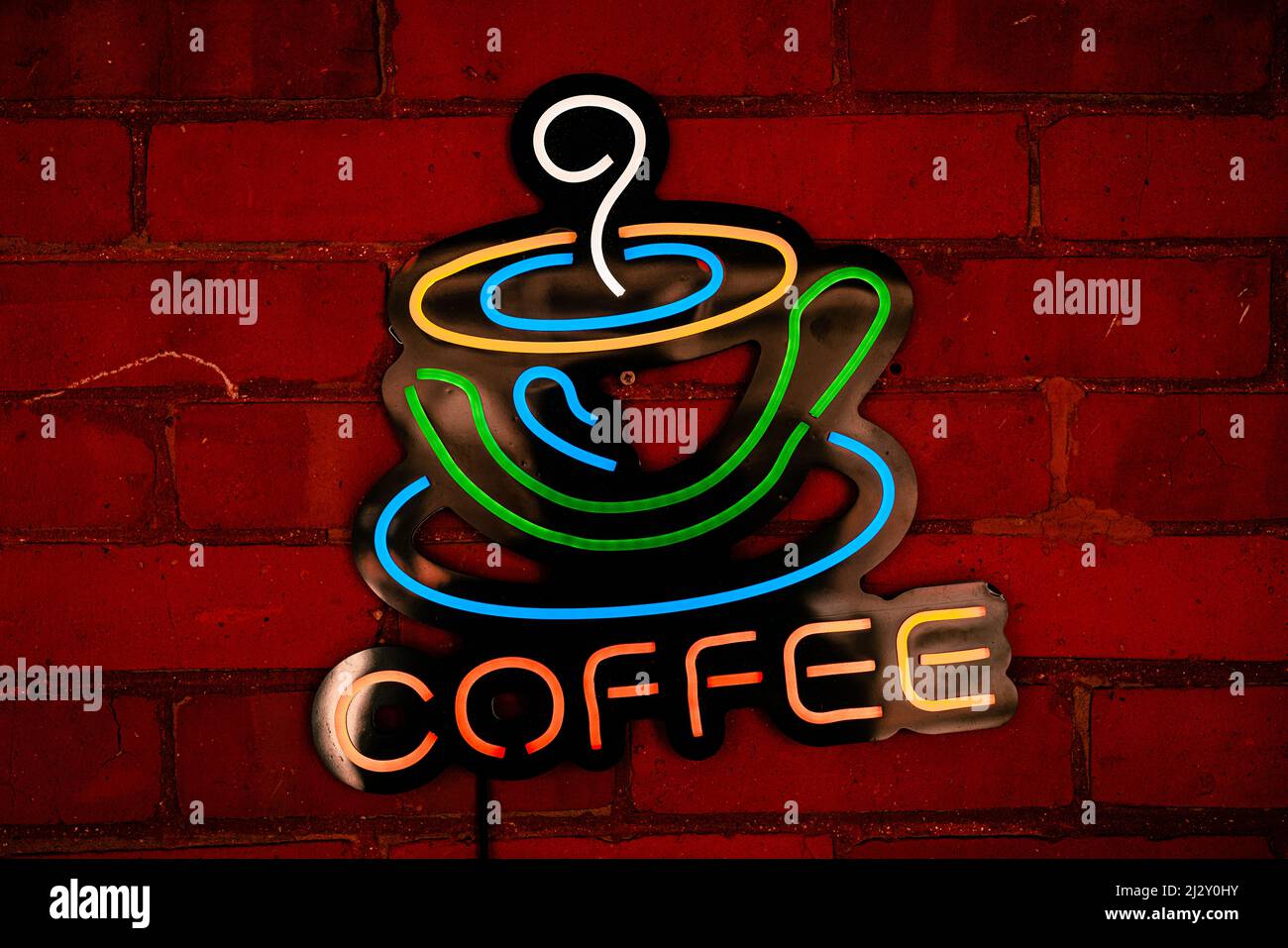 Neon coffee sign on brick wall Stock Photo