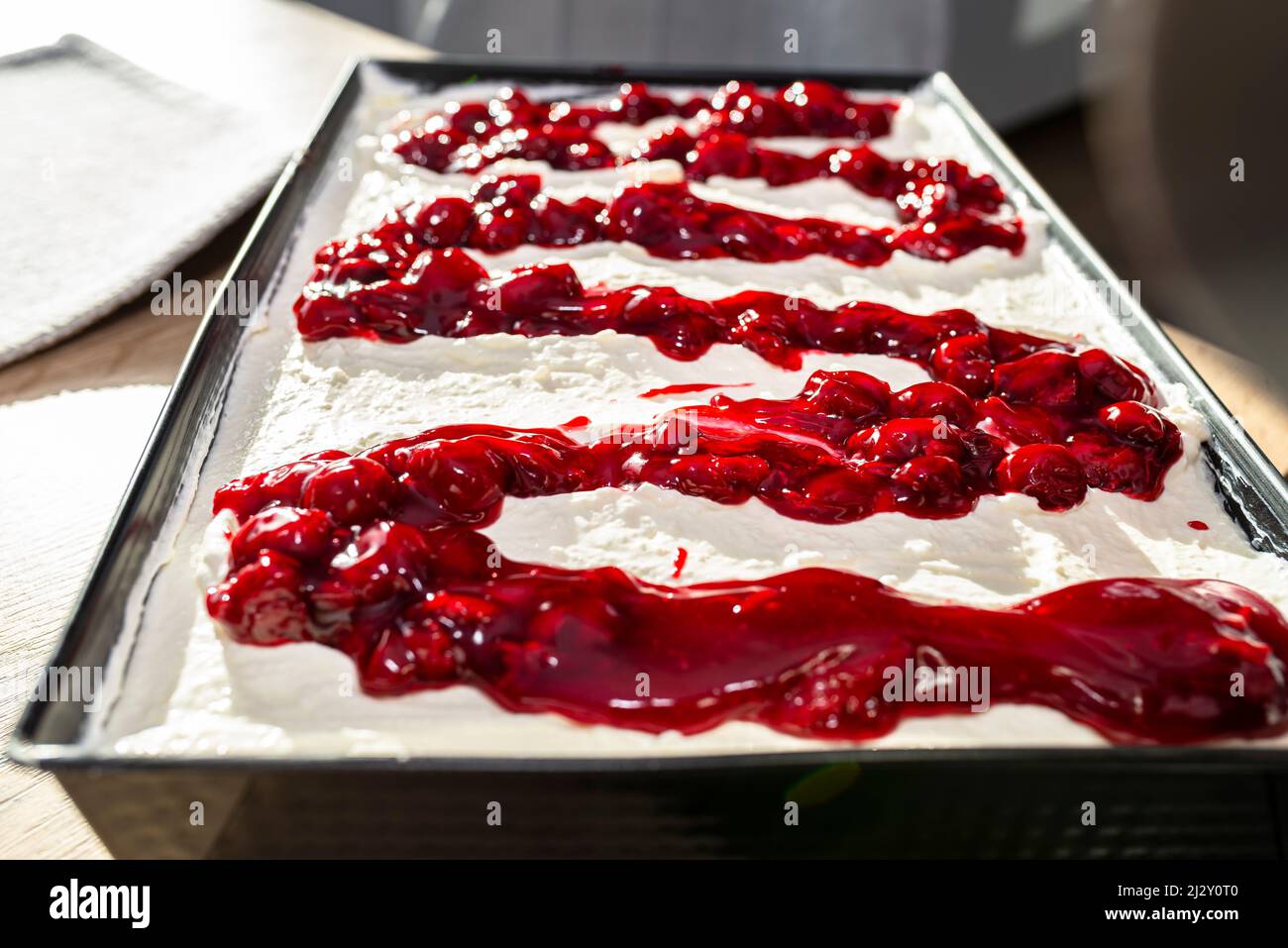 Ready Japanese cake with cottage cheese and whipped cream and fruit cherry sauce. Stock Photo