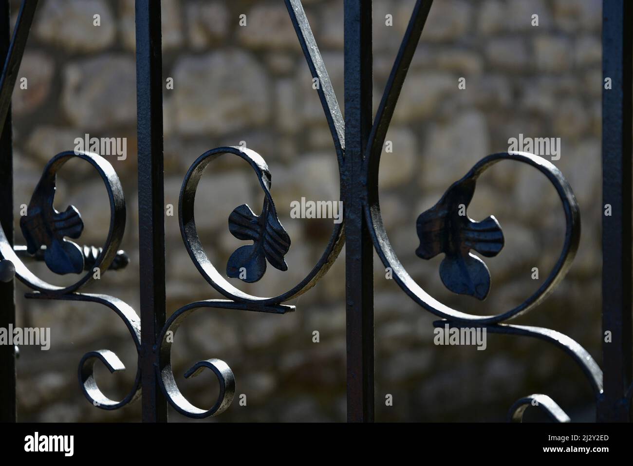 Traditional handcrafted wrought iron entrance gate railing against a ...