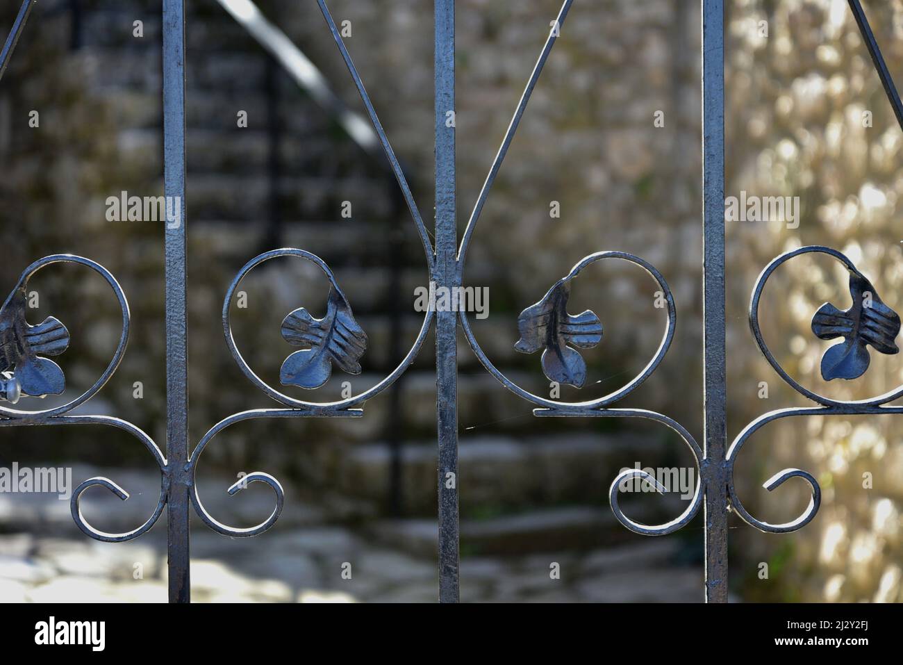 Traditional handcrafted wrought iron entrance gate railing against a ...
