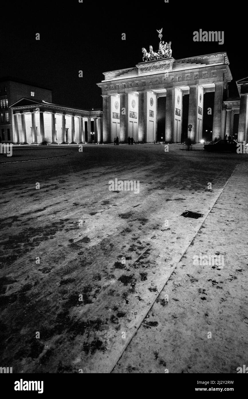 Brandenburg Gate, Berlin, Germany. Wide view of the historic landmark on a cold winters evening.  Black and white with visible film grain. Stock Photo