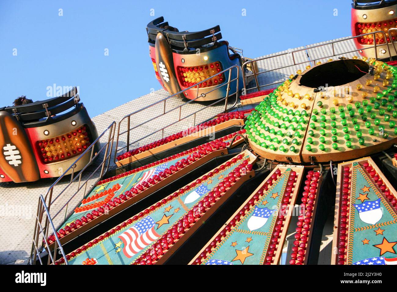 Fairground ride. A brightly decorated and illuminated American style Waltzer ride raising to a vertical position. Stock Photo