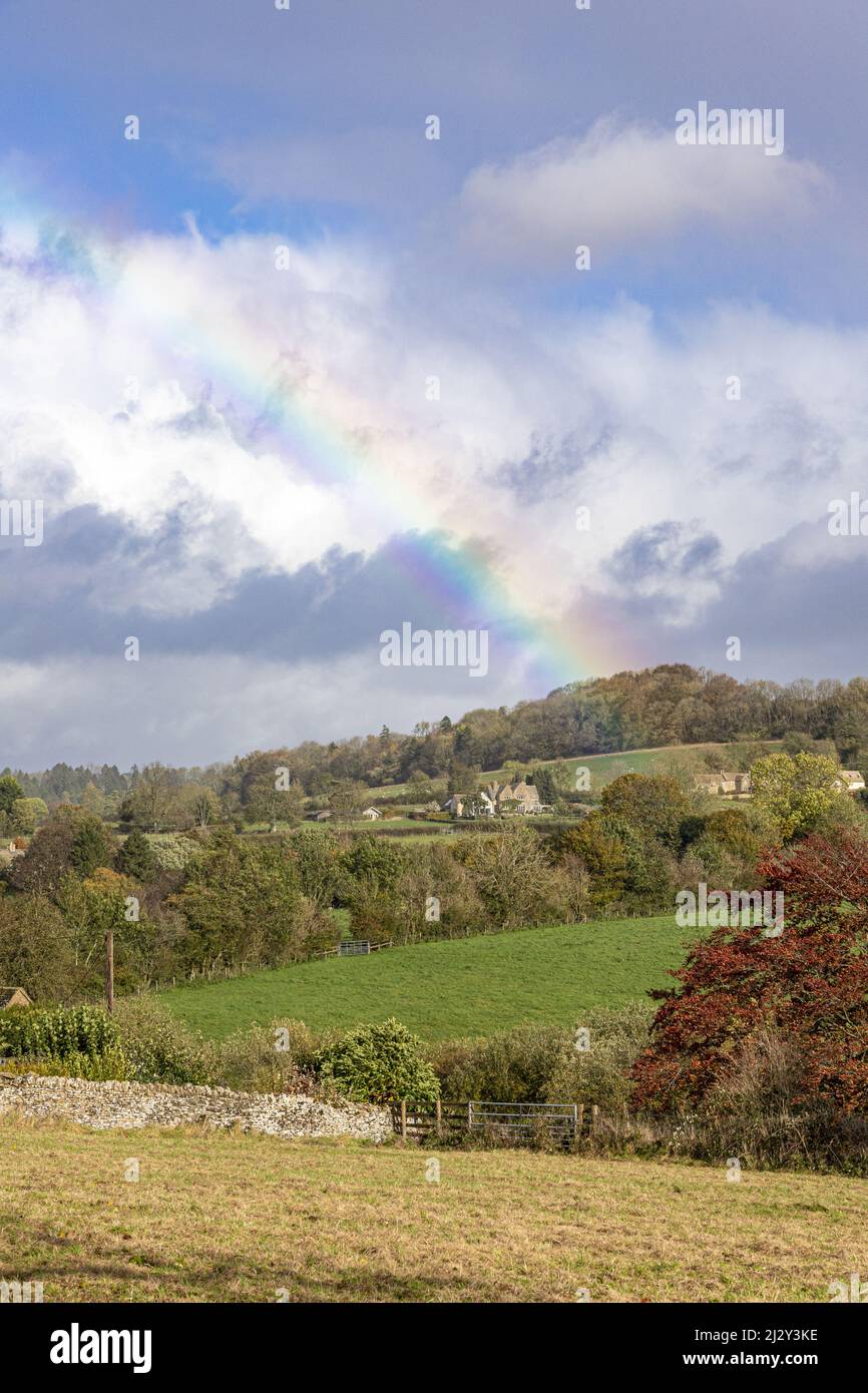 An autumn rainbow in the Cotswold village of Sevenhampton (looking towards Brockhampton), Gloucestershire, England UK Stock Photo