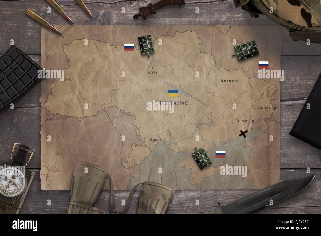 Map of the Russian invasion of Ukraine with military equipment on the table. Top view, flat lay concept composition Stock Photo