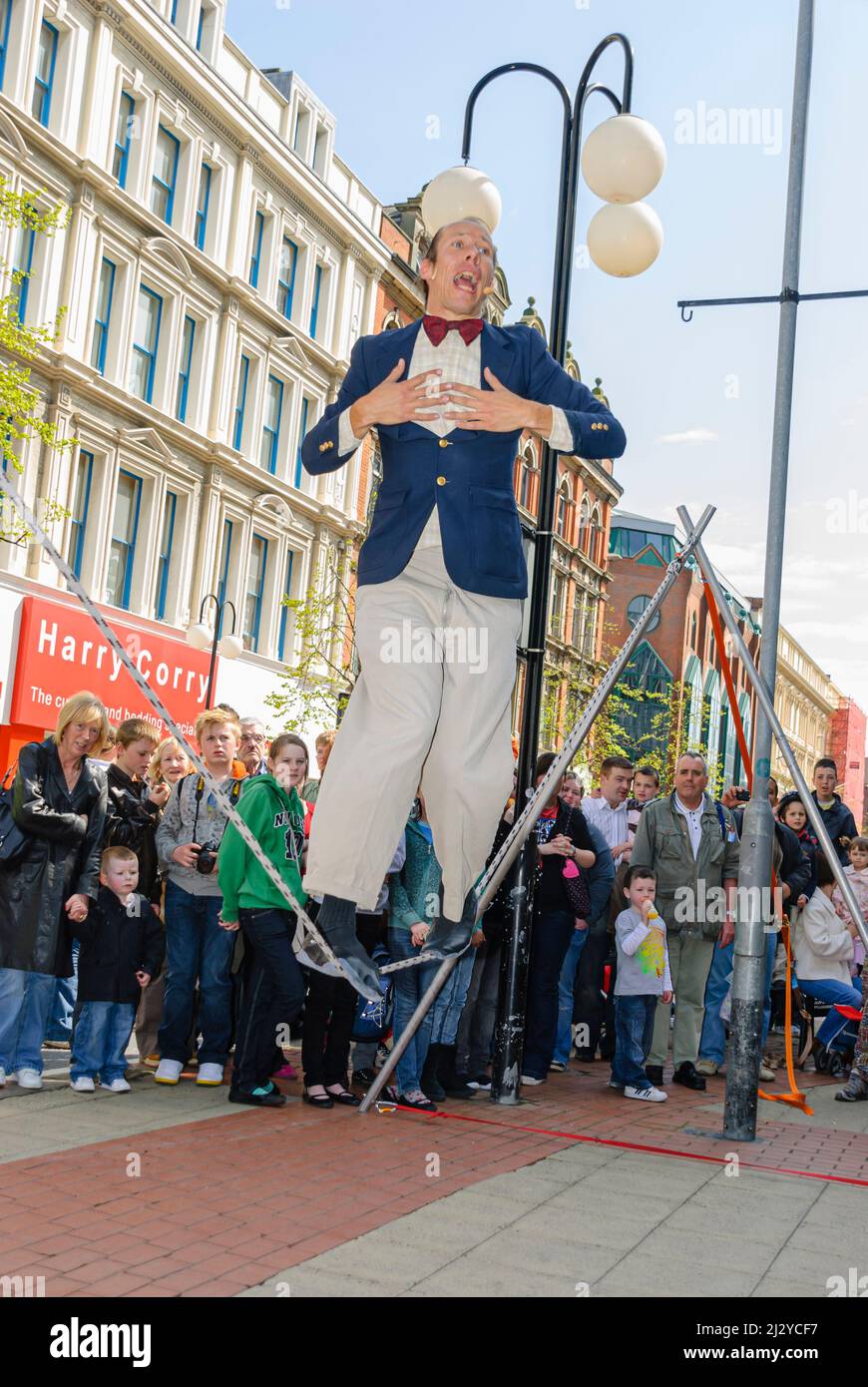 Belfast, Northern Ireland. 3rd May 2008.  A Street performer walks a tightrope as he performs to an audience outside Castle Court Shopping Centre. Stock Photo