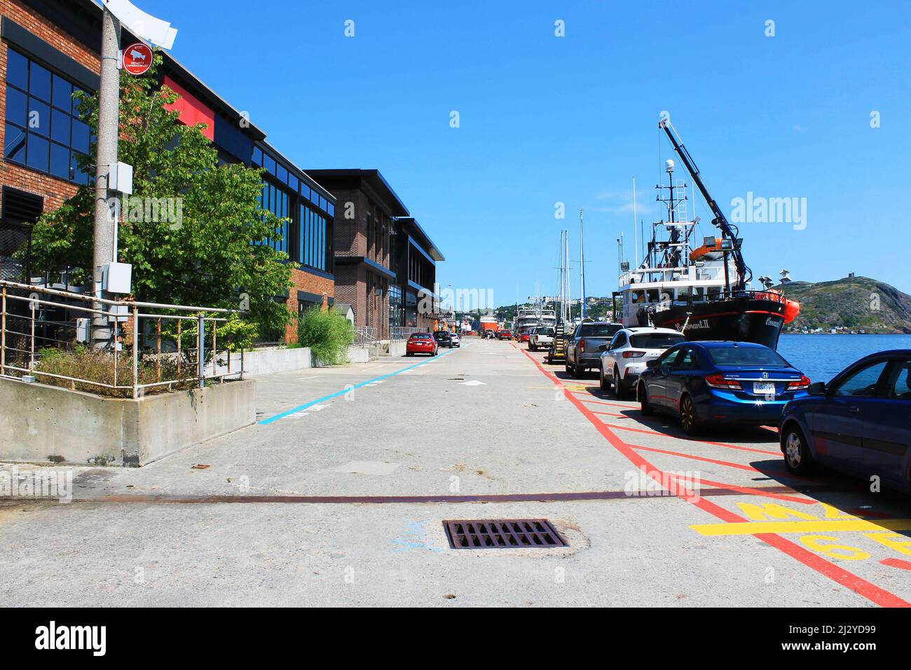 A view looking along the St. john's waterfront, with the harbour on one side and the restaurants and bars on the other. Stock Photo