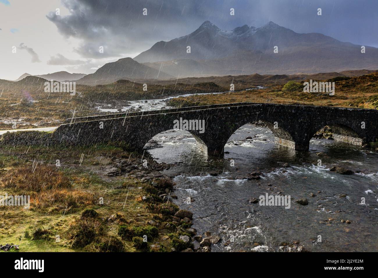 Sun and raindrops, historic stone bridge, Sligachan Bridge, Cuilins mountain range, Isle of Skye, Scotland, UK Stock Photo