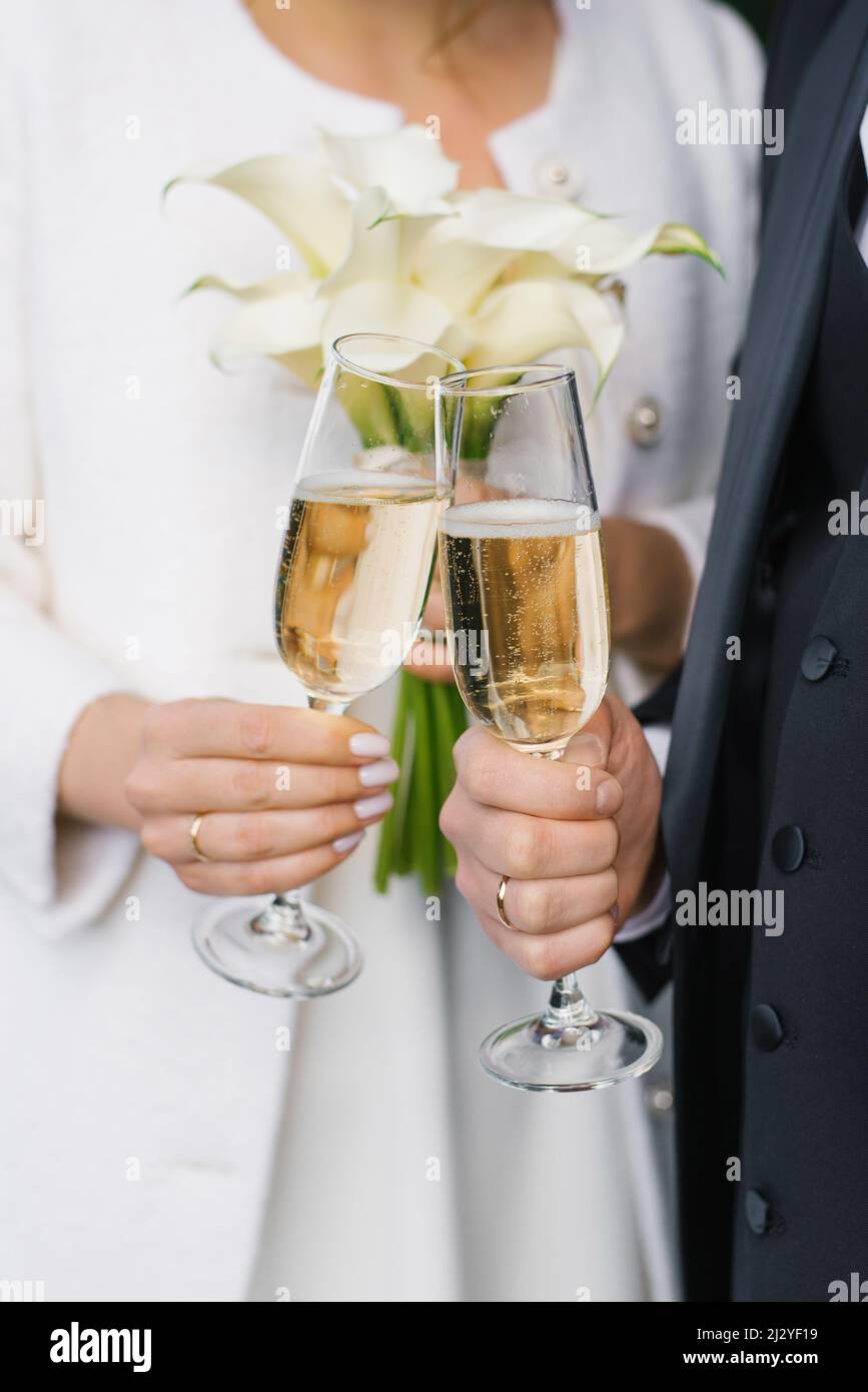 The bride and groom are holding two champagne glasses for the wedding ceremony Stock Photo Alamy