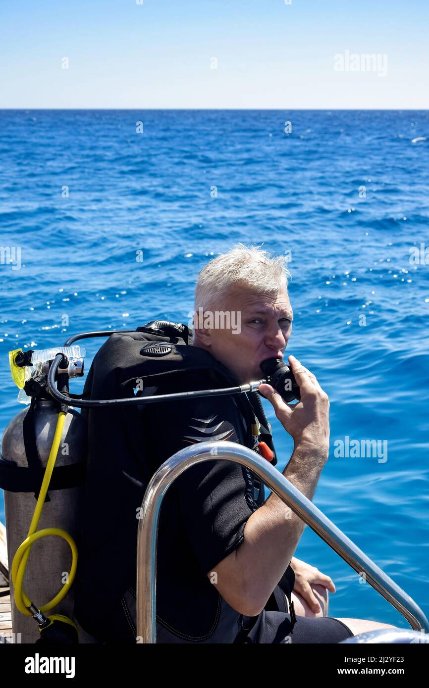 Scuba diver before diving. Diving lesson in open water. Male in scuba diving suit is preparing