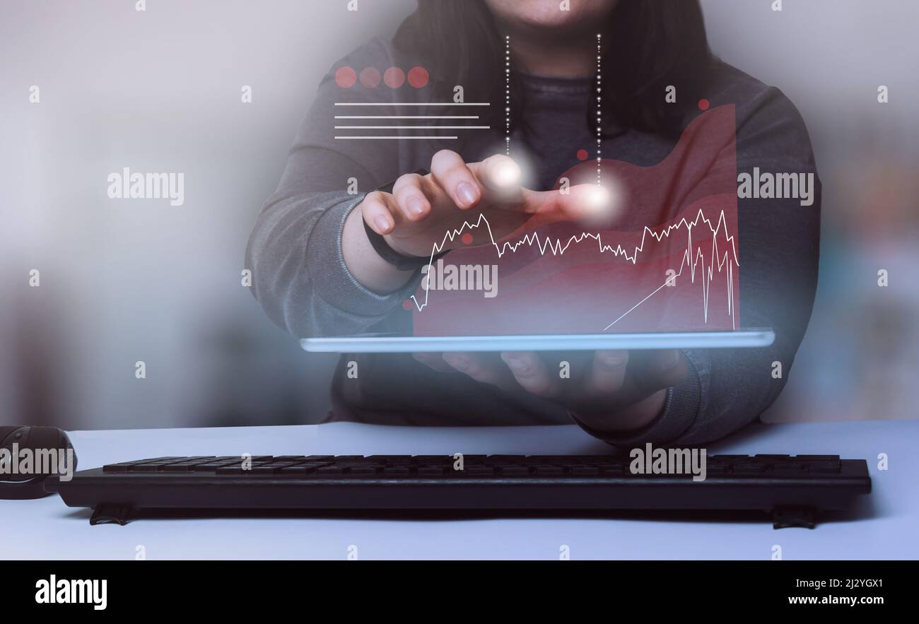 Business woman showing a growing virtual hologram stock on digital tablet. Stock market. Growth, progress and success concept. Stock Photo
