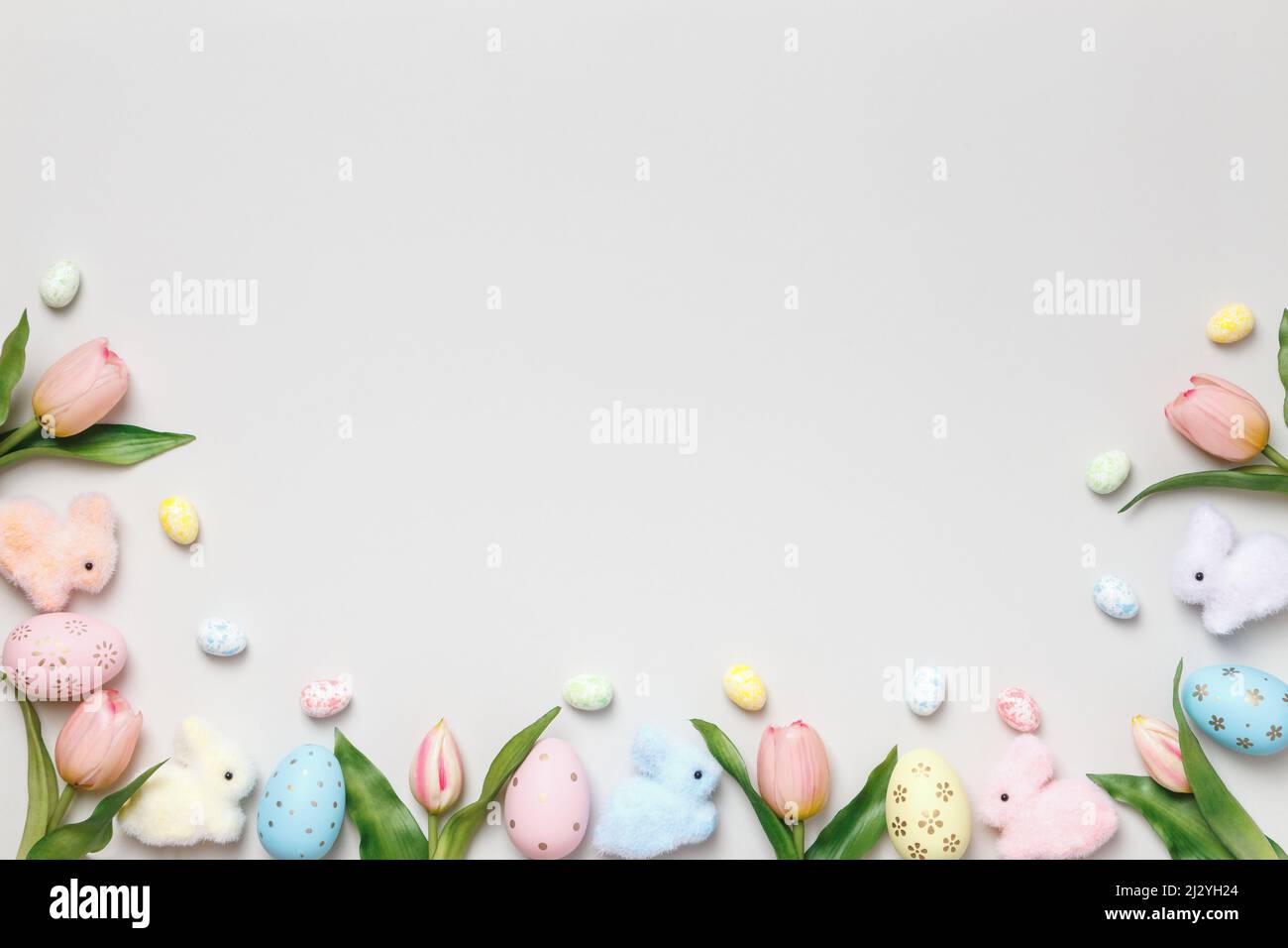 Easter composition. Tulips eggs toy rabbits on a gray background. Stock Photo