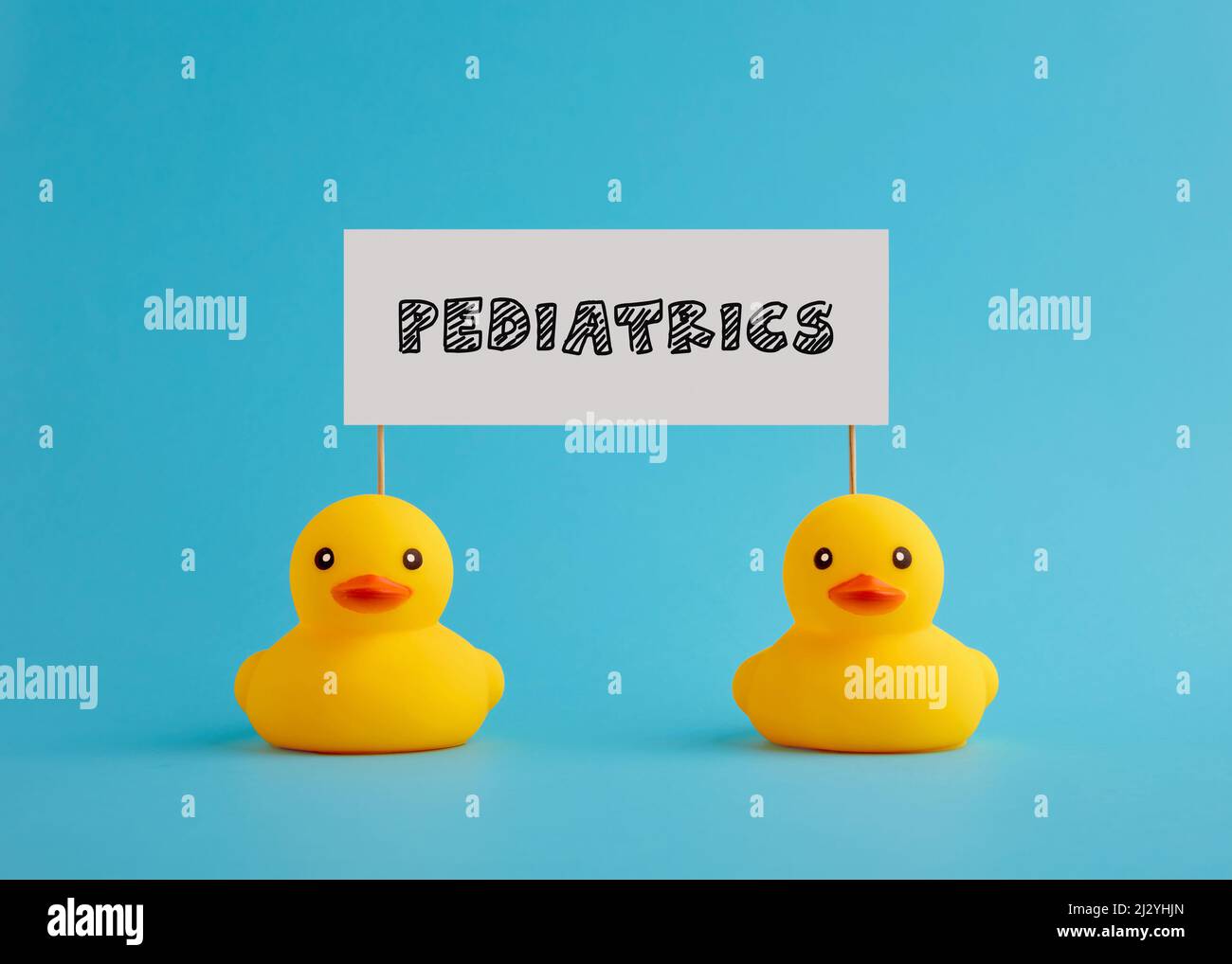 Rubber ducks carry a signboard with the word pediatrics. Children health care concept. Stock Photo