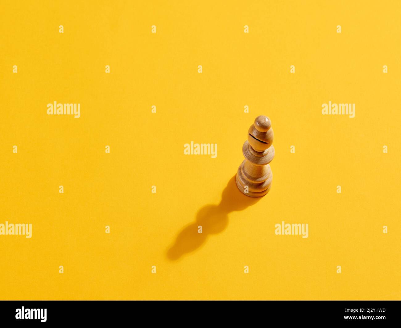 Bishop or elephant chess piece on yellow background with copy space. Stock Photo