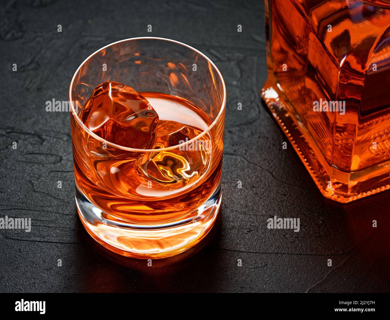 https://c8.alamy.com/comp/2J2YJ7H/glass-of-elegant-whiskey-with-ice-and-whisky-bottle-hard-drink-concept-2J2YJ7H.jpg