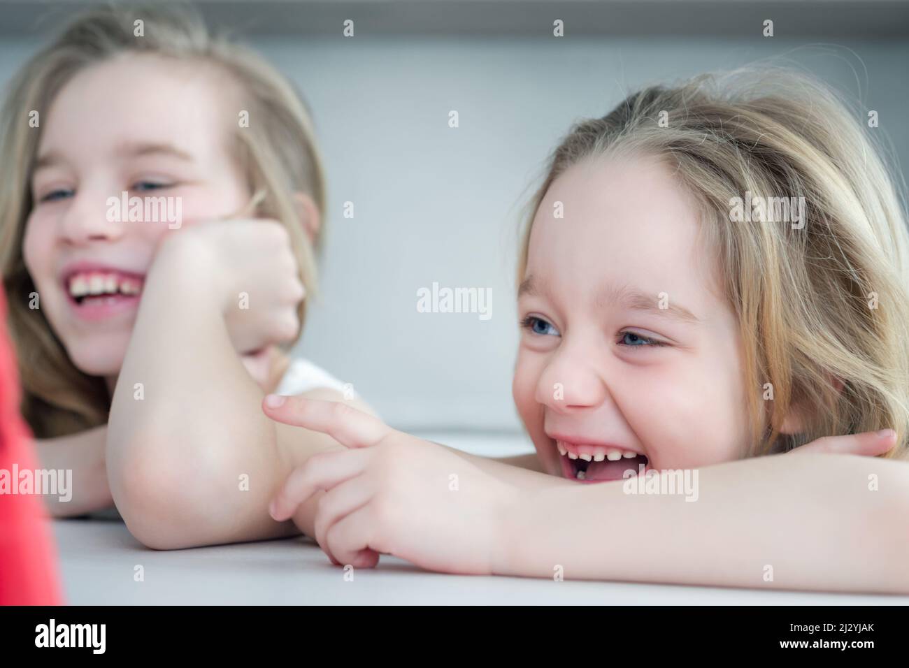 Two girls watching a fun video on the tablet close-up. Online Education concept. Portrait of two children watching TV Stock Photo