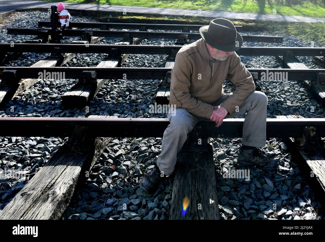 Man sitting on railway track line Stock Photo