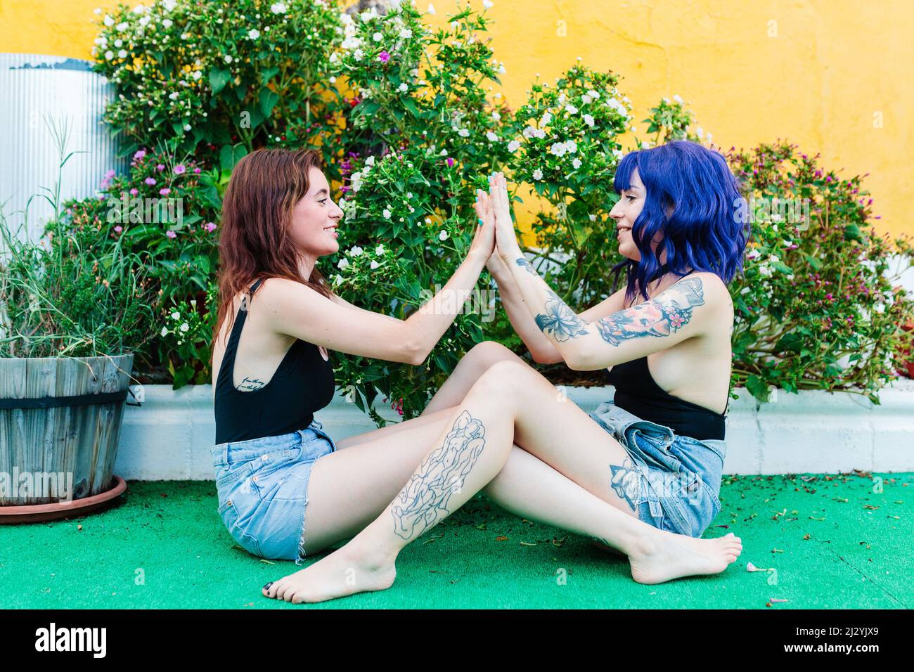 Happy young women playing patty cake in backyard Stock Photo - Alamy