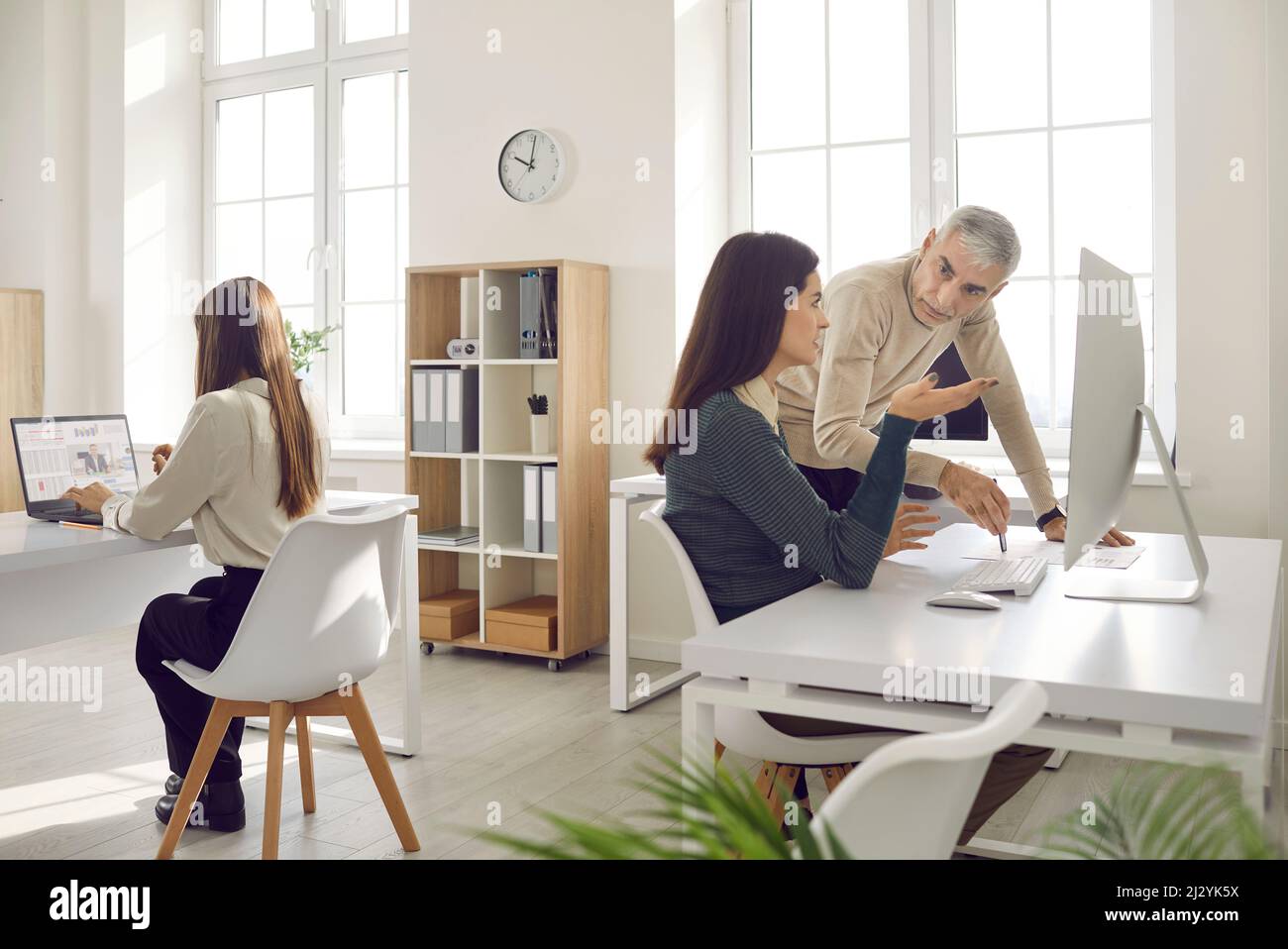 Diverse colleagues work on computer in coworking space Stock Photo